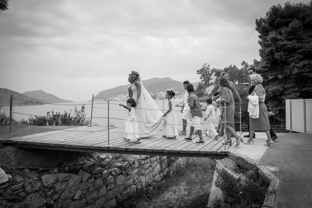 Χαρούμενη νύφη περιστοιχισμένη από την οικογένειά της δίπλα στη θάλασσα στην Ελλάδα.